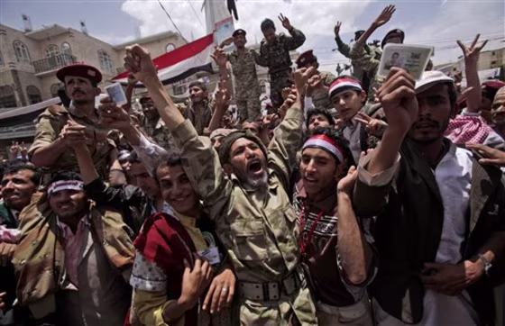 A Yemeni army officer, center, reacts as he and other officers join anti-government protesters in Sanaa, Yemen, Sunday.